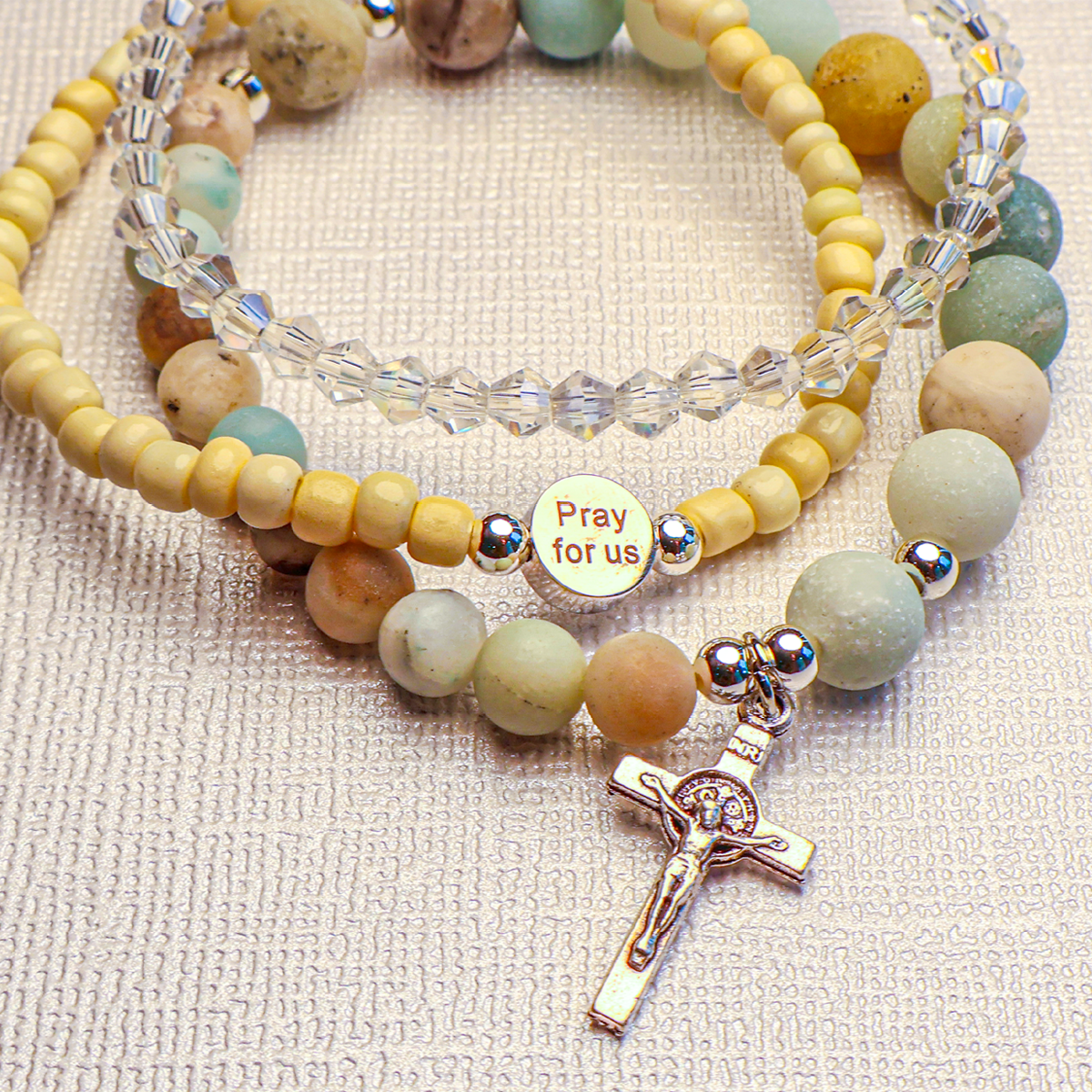 A multicolored beaded bracelet with a cross pendant, designed for prayer.
